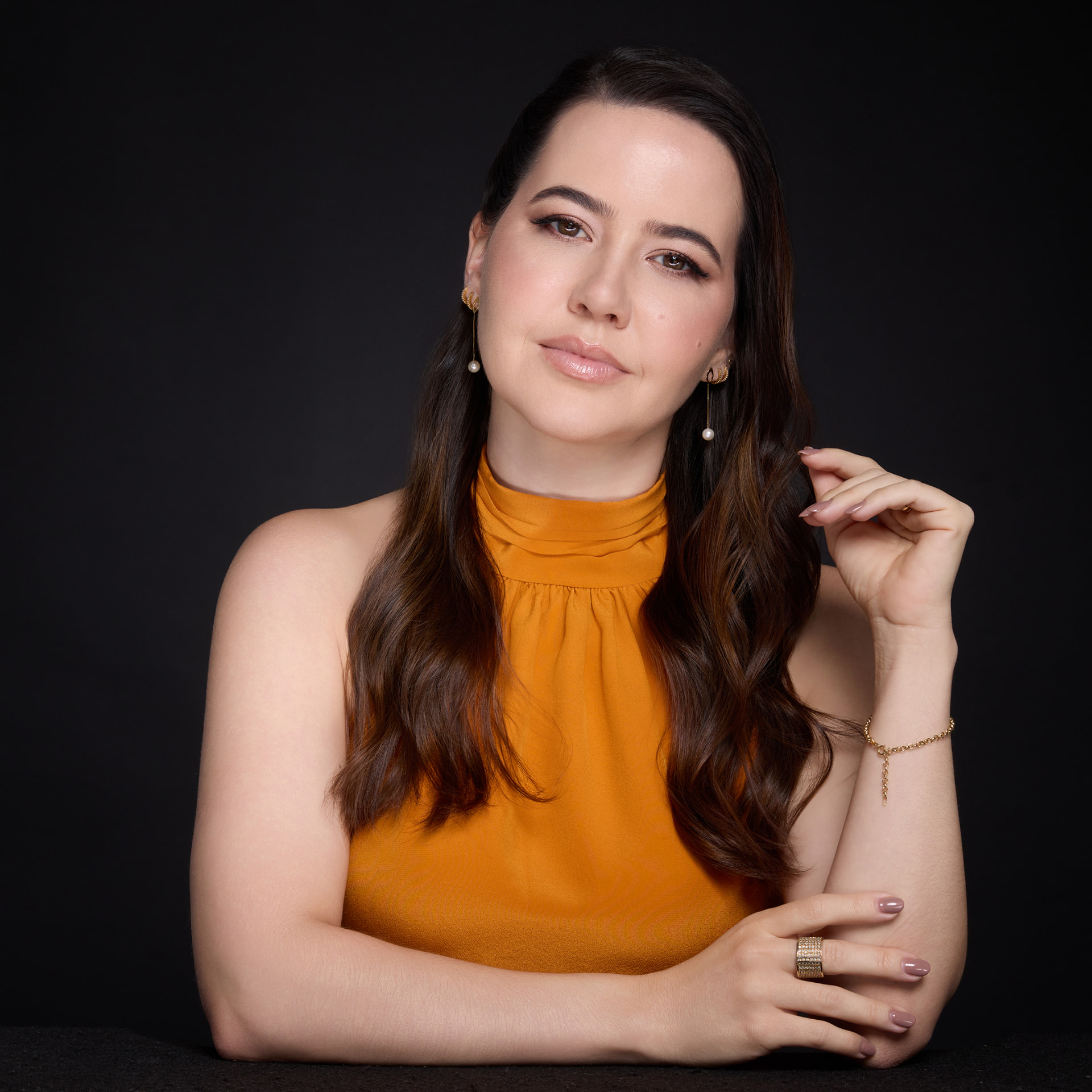 Dra. Taiane Terra apoiada sobre a mesa, retrato em estúdio